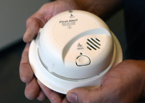 person holding smoke alarm